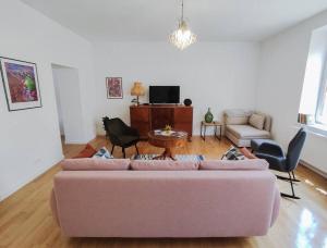 a living room with a pink couch and chairs at Apartment Laizor in Staszów