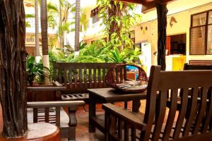 a table and benches on a patio with palm trees at Hotel Rivera Del Mar in Puerto Escondido