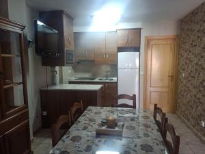 eine Küche mit einem Tisch und Stühlen sowie einem TV in der Unterkunft Vivienda Paula in Arroyo Frio