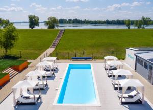 an overhead view of a swimming pool with white chairs at Tisza-tó Apartmanpark in Kisköre