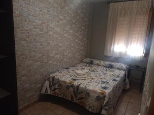 ein Schlafzimmer mit einem Bett und einer Ziegelwand in der Unterkunft Vivienda Paula in Arroyo Frio