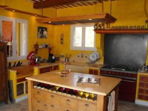 een keuken met gele muren, een wastafel en een fornuis bij Piscine chauffée au calme sur un domaine viticole familial grande maison climatisation in Mondragon