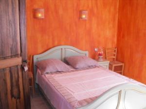een slaapkamer met een wit bed en 2 roze kussens bij Piscine chauffée au calme sur un domaine viticole familial grande maison climatisation in Mondragon