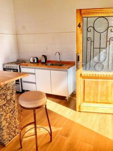 eine Küche mit einem Waschbecken, einem Tisch und einem Stuhl in der Unterkunft Moderno y tranquilo departamento in El Calafate