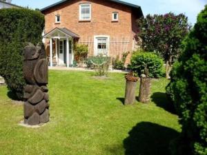 een huis met een tuin met een standbeeld ervoor bij Ruegen_Fewo 241 in Putbus