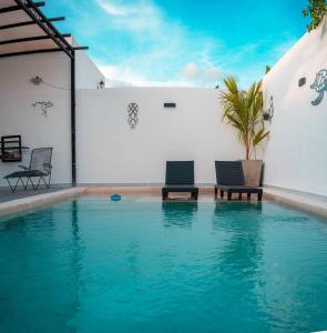 two chairs sitting next to a swimming pool at Casa Lavandas in Mérida