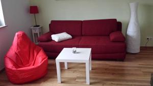 a living room with a red couch and a white table at Ruegen_Fewo 259 in Berglase