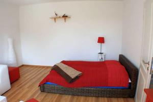 a bedroom with a red bed with a red blanket at Ruegen_Fewo 259 in Berglase