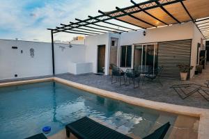 a swimming pool with a patio and a house at Casa Lavandas in Mérida