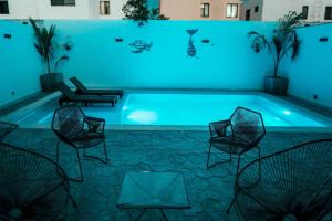 a swimming pool with chairs and a table at Casa Lavandas in Mérida