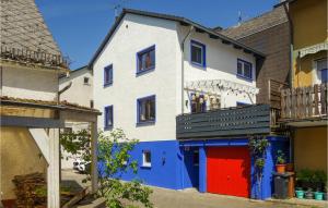 un edificio azul y blanco con garaje rojo en Cozy Home In Ulmen With Kitchen, en Ulmen