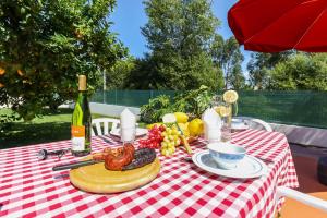 a picnic table with a plate of food and a bottle of wine at Casa do Azal in Ponte de Lima