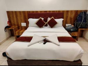 a bedroom with a large bed with two pillows at NEW ROYAL LODGE in Mangalore
