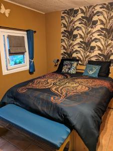 um quarto com uma cama com um cobertor de dragão em Au ' Bord des Landes ' em Cazalis