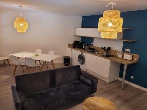 a living room with a black couch and a table at Magnifique appartement t2 in Collobrières