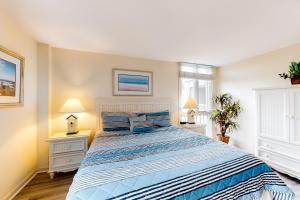 a bedroom with a large bed with blue and white sheets at Ketch Court 893 in Hilton Head Island