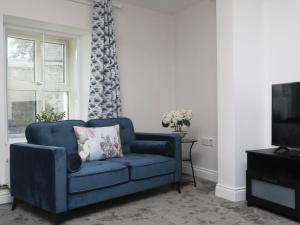 un sofá azul en la sala de estar con TV en Picturesque 3 bed house, Killala, en Killala