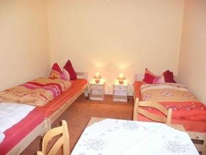 two beds in a room with two tables and chairs at Ruegen_Fewo 102 in Sagard +21 photos