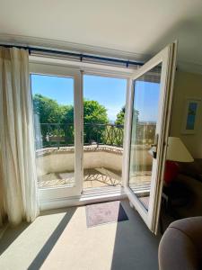 a room with two large windows and a balcony at Golf Court View, Elie in Elie