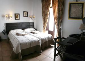 um quarto com uma cama, uma secretária e uma janela em La Posada Del Infante em La Puebla de los Infantes