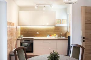 uma cozinha com armários brancos e uma mesa com cadeiras em W21 Central Apartment em Budapeste