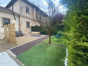 un jardín con una mesa y un árbol frente a una casa en APARTAMENTOS TURÍSTICOS WAMBALORE, en Pampliega