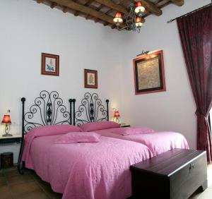a bedroom with a bed with a pink bedspread at La Posada Del Infante in La Puebla de los Infantes