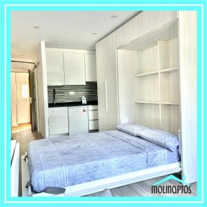 Un dormitorio con una cama y una cocina. en Estudio 29 Frente al Mar by Molinaptos, en Benidorm