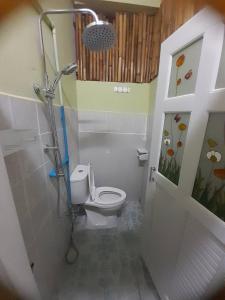 a small bathroom with a toilet and a shower at My Travel Homestay in Haad Rin