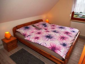 - une chambre dotée d'un lit avec des draps de fleurs roses et violets dans l'établissement Ruegen Fewo 79, à Putbus