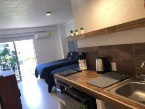 una cocina con fregadero y una cama en una habitación en SKY INN Acapulco Y condominio mediterrane en Acapulco