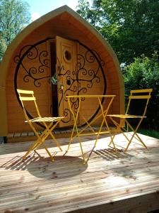 dwa krzesła i stół przed domem zabaw w obiekcie Le Rocher du Samoyède w mieście Dirinon
