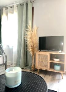 uma sala de estar com uma televisão e uma mesa em Appartement avec plage et parking em Pietranera