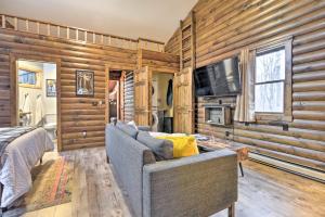 een woonkamer met houten wanden, een bank en een tv bij Alpine Lake Cabin Mountain Resort w Lake Access in Terra Alta