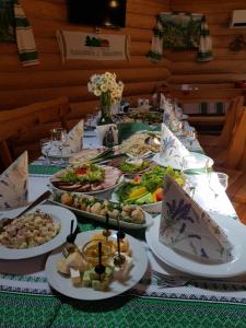 a table with many plates of food on it at Chudodievo in Chynadievo Mini-Hotel in Chynadiyovo