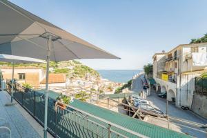 uma varanda com um guarda-sol e vista para a cidade em Residenza Sant'Angelo - Art Apartment em Minori