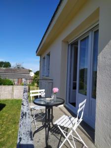 een patio met een tafel en stoelen op een balkon bij La Haute Maison - Merrien - GR34 in Moëlan-sur-Mer