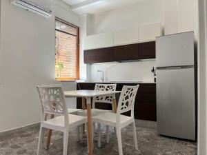 uma cozinha com uma mesa e cadeiras e um frigorífico em Davis Apartment em Brindisi