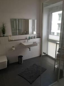 een badkamer met een wastafel en een spiegel bij FeWo Pearl 207 am Yachthafen inkl. Tiefgarage in Bremerhaven