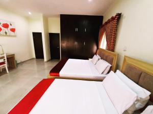 a bedroom with two beds and a chair in it at The Ambassadors Hotel in Lagos