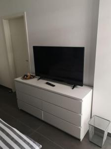 een flatscreen-tv zittend op een wit dressoir bij FeWo Pearl 207 am Yachthafen inkl. Tiefgarage in Bremerhaven