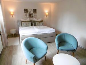 een kleine kamer met een bed en twee stoelen bij Ferienwohnung Muschelbank_ MV_Fewo in Stralsund