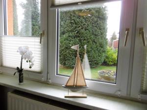 a window with a model boat on a window sill at Ferienwohnung Muschelbank_ MV_Fewo in Stralsund