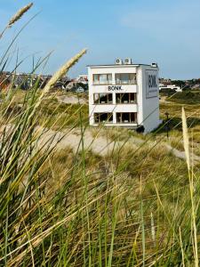 ein Gebäude am Strand neben einem Grasfeld in der Unterkunft BONK suites in Middelkerke