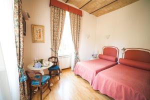 sypialnia z 2 łóżkami, stołem i oknem w obiekcie Villa Paganini B&B w Rzymie