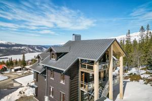 een huis in de sneeuw met een metalen dak bij Åre's best family home in Åre