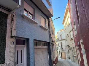 eine Gasse mit einem Garagentor und einem Gebäude in der Unterkunft Apartamento puerto in A Guarda