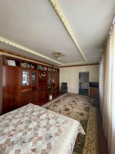 1 dormitorio grande con 1 cama y 1 alfombra grande en family homestay en Osh