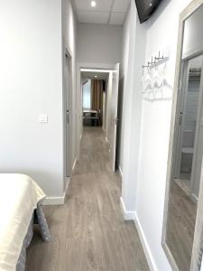 a hallway with a bed and a mirror in a room at Apartamentos Aranda - Roble in Aranda de Duero