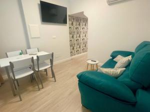 ein Wohnzimmer mit einem Sofa und einem Esstisch in der Unterkunft Apartamentos Aranda - Roble in Aranda de Duero